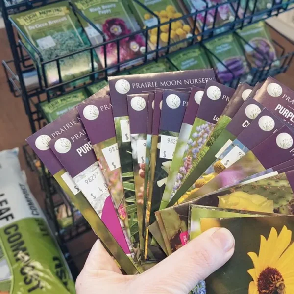 Selection of colorful Prairie Moon Native Plant seed packets held in hand