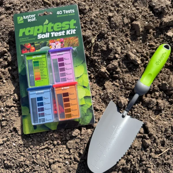 Soil test kit on ground next to colorful green trowel